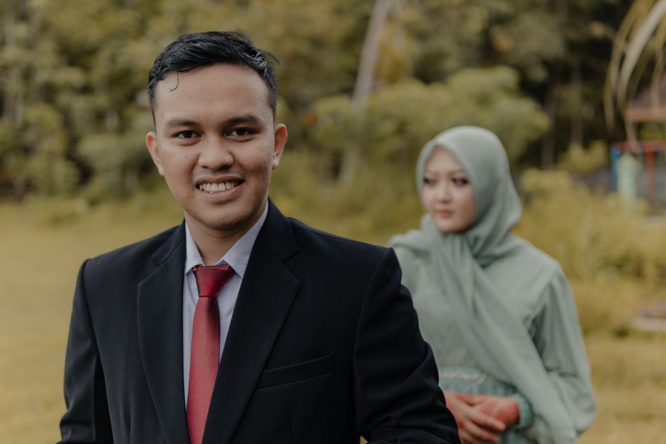 A couple in traditional attire poses for a pre-wedding photoshoot in the lush outdoors of Pacitan, Indonesia.