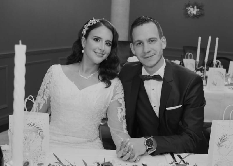 Les mariés attablés pendant la réception, portrait en noir et blanc